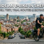 Cyclist riding an electric bike smoothly up a steep cobbled Sheffield hill street with city skyline view